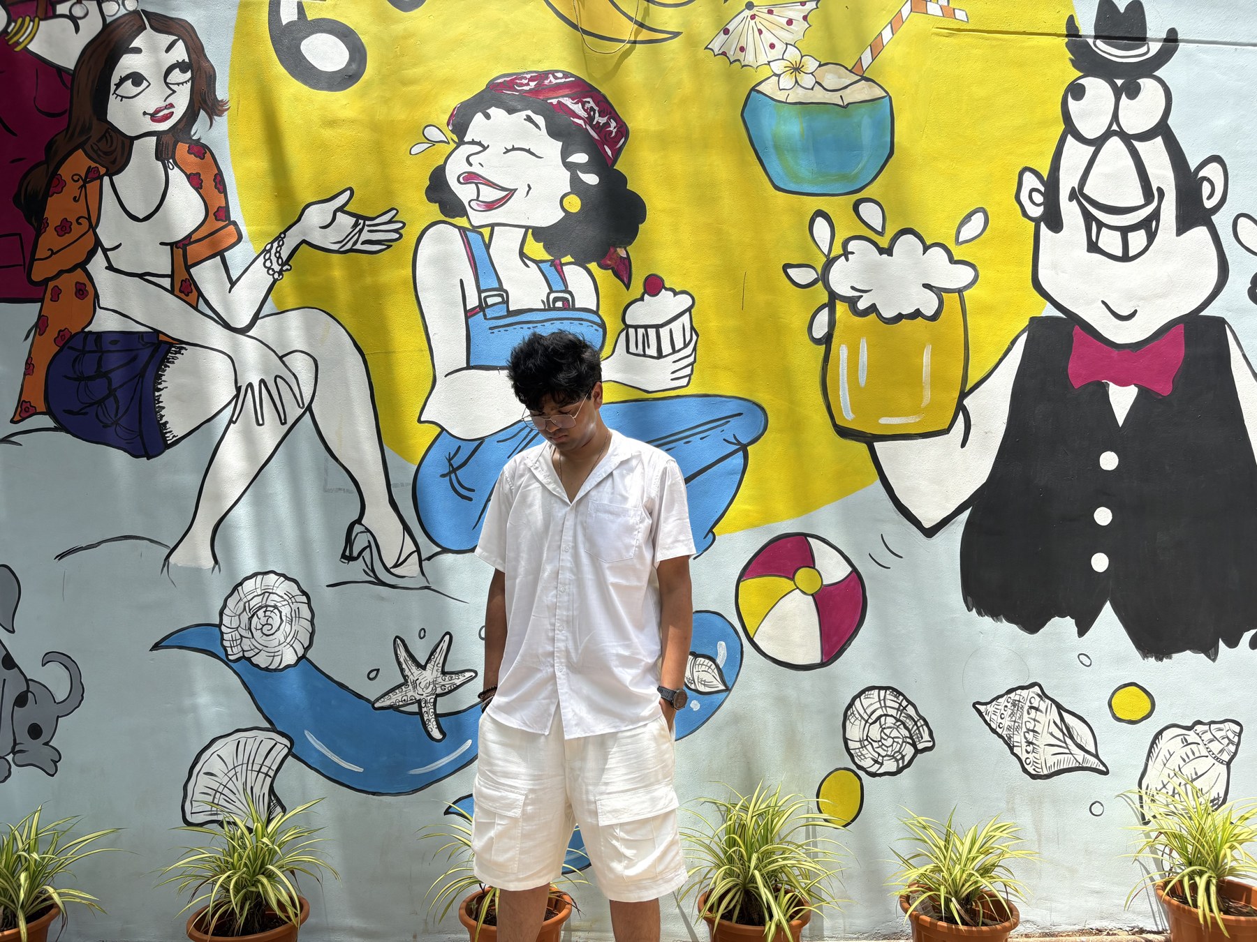 Somesh standing beside a colourful mural