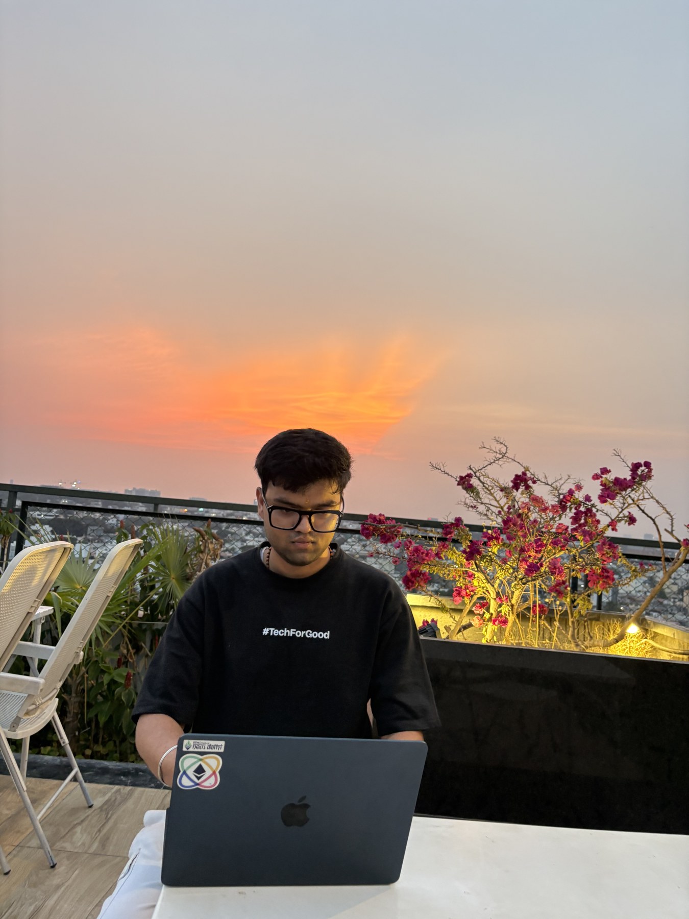 Somesh working on his laptop outdoors at sunset